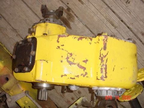 1971 Ford Bronco - Close-up of a yellow transfer case, likely for an off-road vehicle, showing wear and tear.