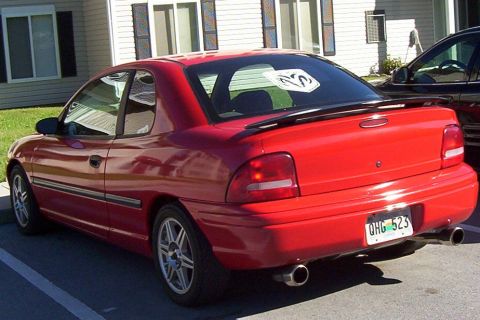 1997 Ford Taurus - The rear view of a red coupe shows a spoiler and dual exhaust pipes.