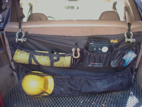 1993 Ford Bronco - This 1993 Ford Bronco features a rear cargo organizer with multiple pockets holding various items, including a radio and yellow gear.