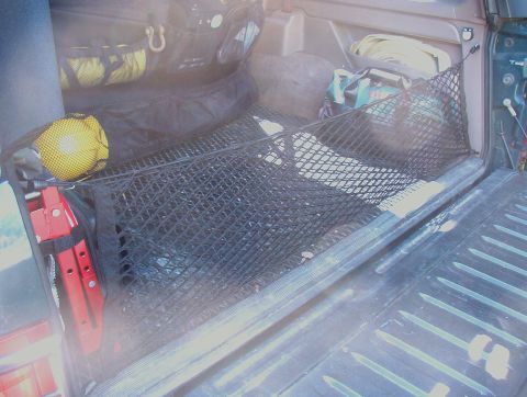 1993 Ford Bronco - Cargo net secures various items within the bed of a pickup truck.