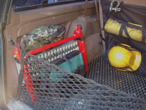 1993 Ford Bronco - The cargo area of a vehicle contains various tools and storage solutions.
