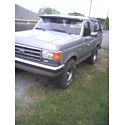 1995 Ford Bronco - Small, low-resolution thumbnail of a two-tone silver and gray full-size Ford Bronco parked on grass beside a driveway, shot from the front…