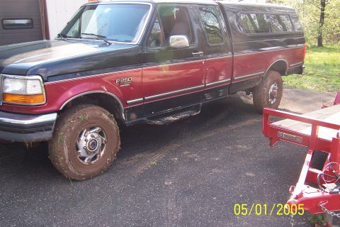 1979 Ford Bronco - This red and black Ford F-250 pickup truck is equipped with a camper shell and appears to be ready for towing.