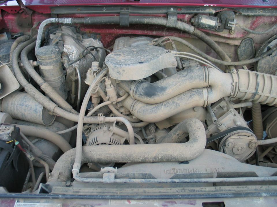Engine bay with dusty intake manifold and hoses