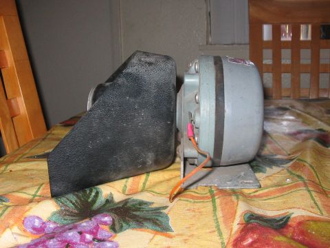1986 Ford Bronco - A vehicle horn part is shown from the side, resting on a patterned cloth.