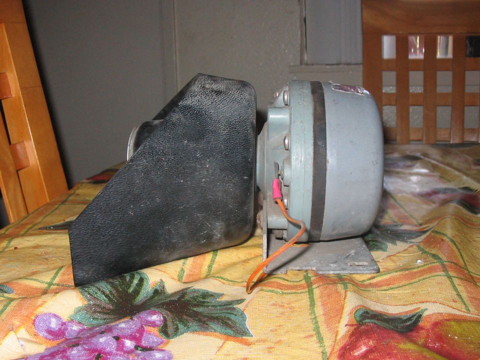 Black plastic horn cover and gray motor with red wire connector