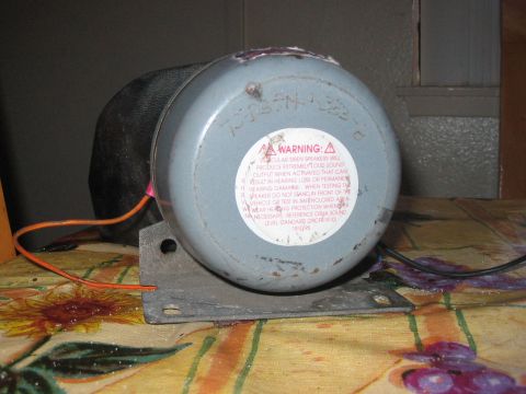 1986 Ford Bronco - A close-up view of a speaker motor with warning labels and wiring visible.