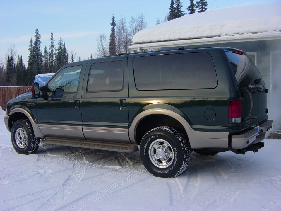 Dark green and tan full-size SUV parked on snow with BFGoodrich all-terrain tires