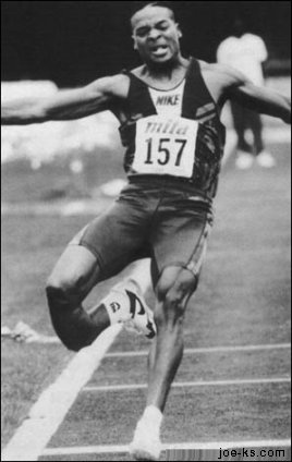 1990 Ford Bronco - Athlete number 157 breaks the tape at the finish line during a race.
