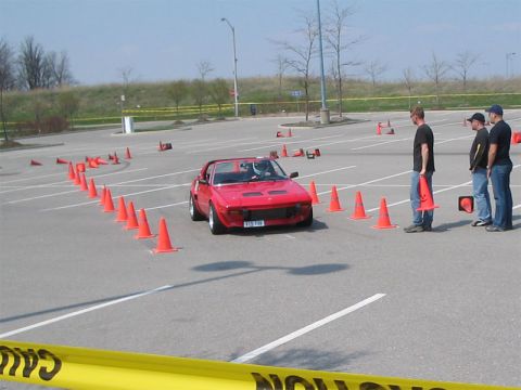 1993 Ford Probe - A red sports car is participating in an autocross event on a paved lot.
