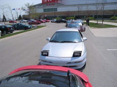1993 Ford Probe - Several cars are parked in a lot in front of a large building with a sign that says HERSHEY CENTRE.