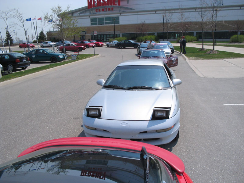 White Ford Probe with pop-up headlights up in a car show lineup at the Hershey Centre