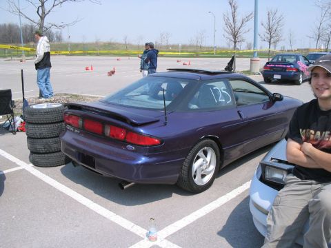 1993 Ford Probe - A purple 1993 Ford Probe is parked in a lot, possibly for an autocross event, with a racing number on its window.