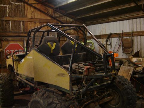 1989 Ford Bronco - Custom buggy with roll cage and racing seats is seen in a garage setting.