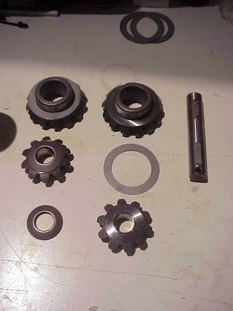 1989 Ford Bronco - Various gears and washers are arranged on a flat surface, suggesting automotive parts.