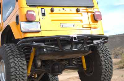 1988 Ford Bronco - The rear of a yellow Jeep Wrangler is shown, a custom bumper and suspension components.