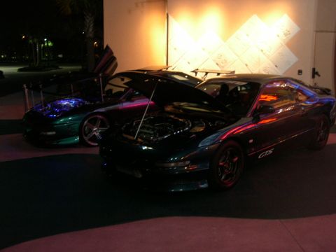 1997 Ford Probe - Two sports cars, including a 1997 Ford Probe GTS, are displayed with their hoods open.