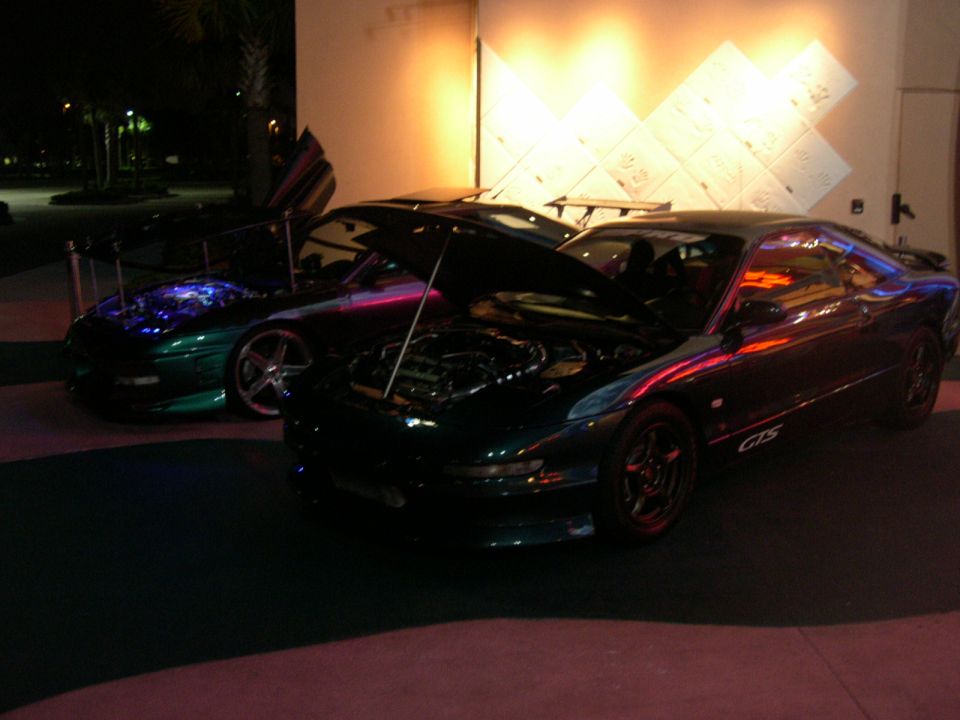 1997 Ford Probe GTS and another sports car parked at night, both with hoods open
