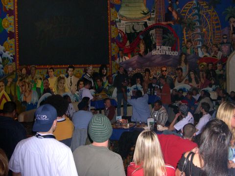 1997 Ford Probe - A lively scene unfolds inside a Planet Hollywood, adorned with a vibrant mural depicting movie stars and iconic imagery.