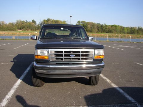 1995 Ford Bronco - This 1995 Ford Bronco is shown from the front in a parking lot near a body of water.