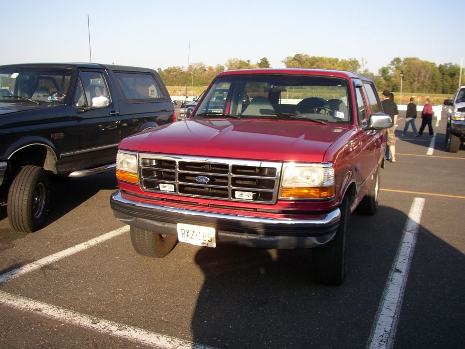 Red Ford Bronco front three-quarter in parking lot with NJ plate RXZ-18S