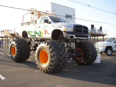 1995 Ford Bronco - A custom monster truck with large tires and a snake graphic is displayed outdoors, with another truck visible in the background.