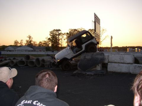 1995 Ford Bronco - White Jeep Wrangler navigating a challenging obstacle course at sunset.