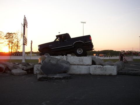 1995 Ford Bronco - A black 1995 Ford Bronco is positioned on a stack of concrete blocks at an outdoor event.