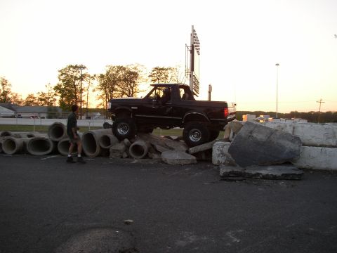 1995 Ford Bronco - This black Ford Bronco is navigating an obstacle course made of concrete pipes and large rocks.