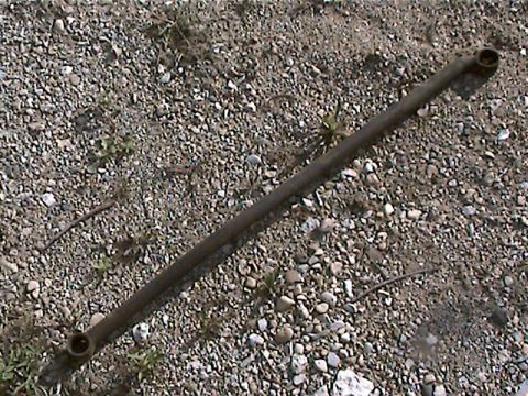 1977 Ford F-150 - A metal rod with threaded ends lies on a gravel surface.
