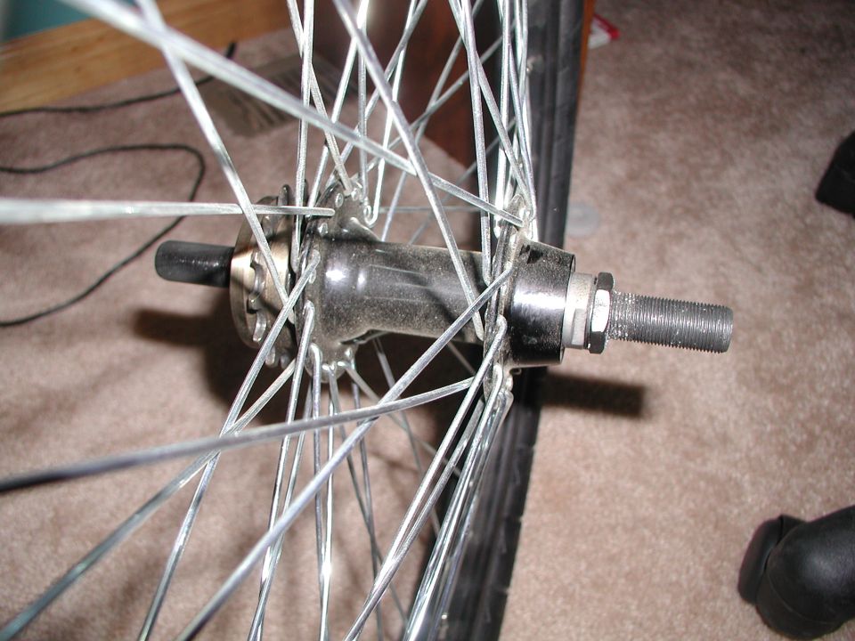 Close-up of a bicycle wheel hub with spokes and a threaded axle