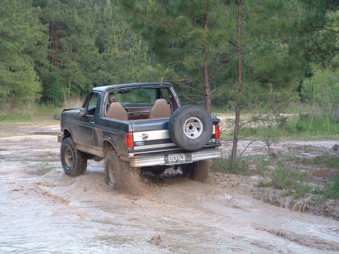 1993 Ford Bronco - This 1993 Ford Bronco navigates a muddy trail, kicking up water and dirt.