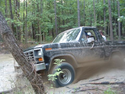 1993 Ford Bronco - This 1980s Ford Bronco is shown off-roading through a muddy, wooded area.