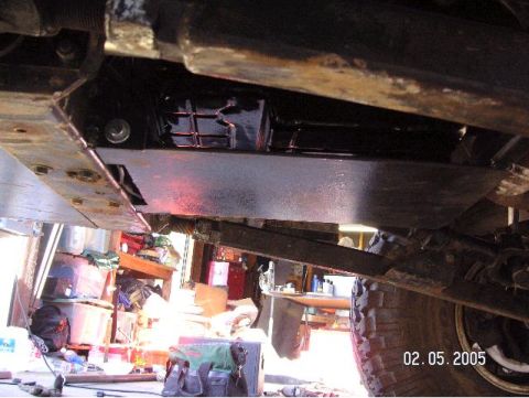 1999 Jeep Grand Cherokee - The underside of a vehicle is shown, with a skid plate and suspension parts visible, along with a tire and a date stamp.