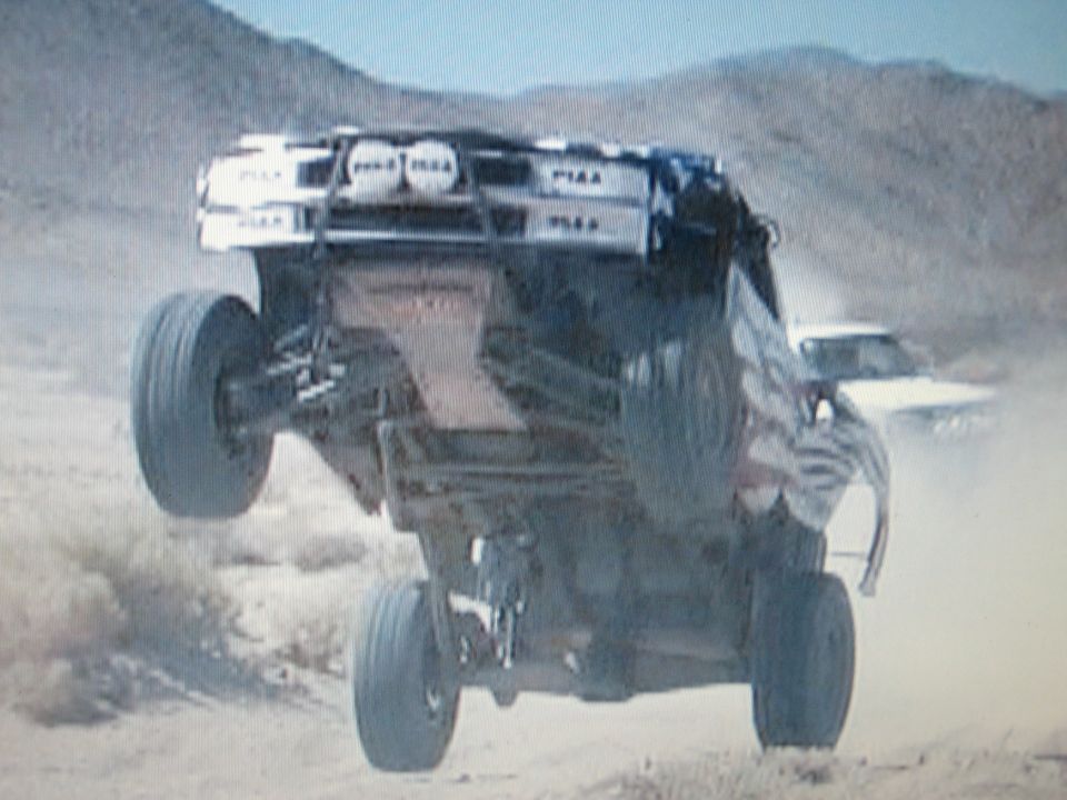 Off-road truck airborne showing underside with PIAA-labeled roof lights
