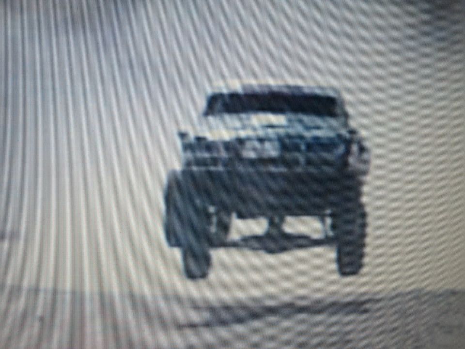 Off-road race truck airborne front-on over desert dirt
