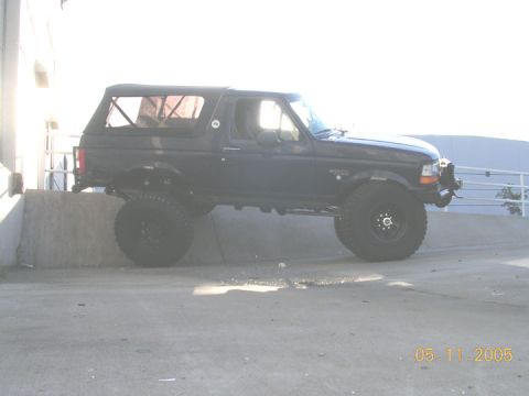 1994 Ford Bronco - Side view of a modified 1994 Ford Bronco with large tires and custom wheels.
