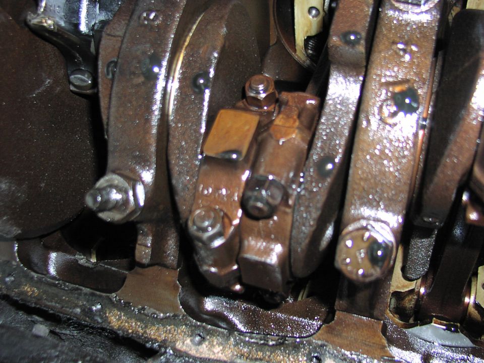 Engine bottom end with oil pan off, showing crankshaft counterweights and main caps