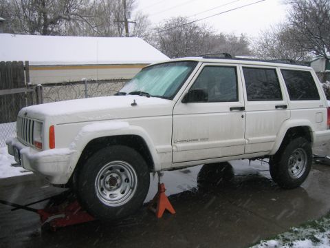 1997 Jeep Cherokee - A white 1997 Jeep Cherokee is parked on jack stands in a snowy environment.