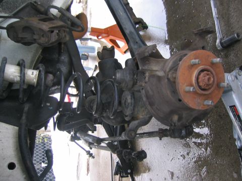 1997 Jeep Cherokee - Close-up of a vehicle's front suspension and brake assembly, showing various mechanical components.