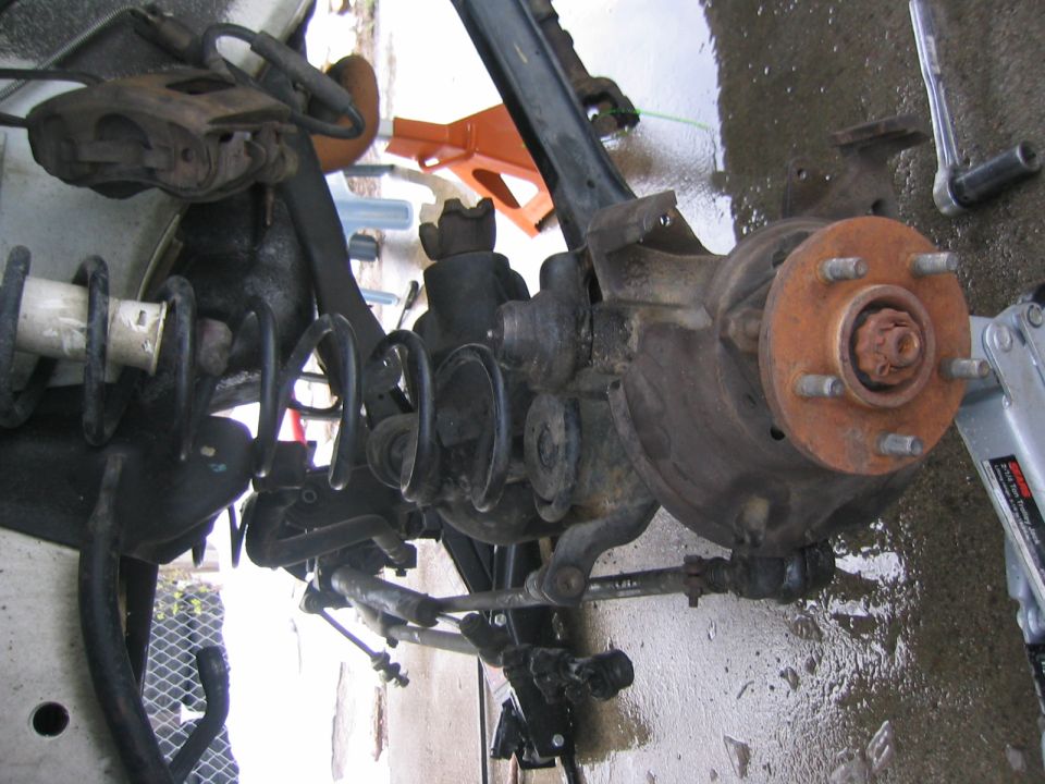 Front suspension and brake assembly with rusty rotor and coil spring
