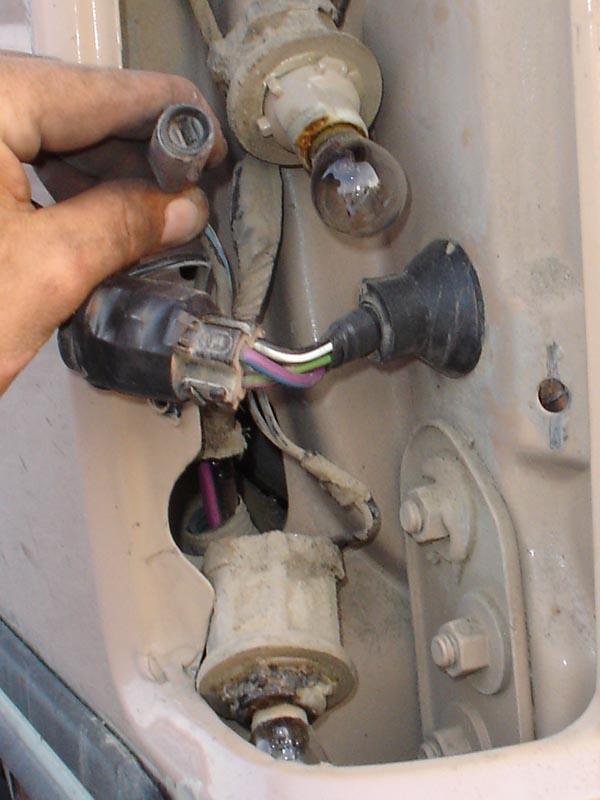 Tail light assembly with exposed wiring and bulbs being worked on