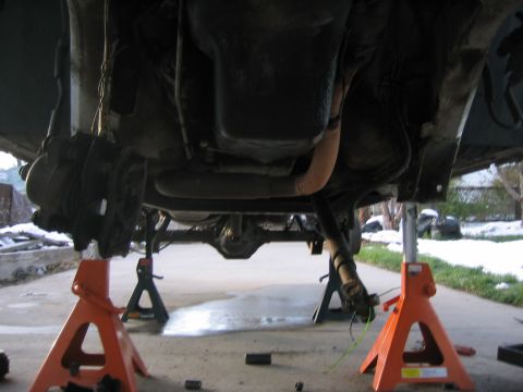1997 Jeep Cherokee - The underside of a vehicle is shown elevated on jack stands, revealing suspension and exhaust systems.
