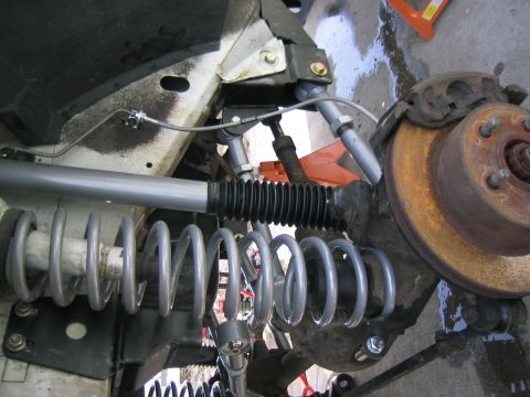 1997 Jeep Cherokee - The front suspension of a Jeep Cherokee is shown with new coil springs and shock absorbers installed.