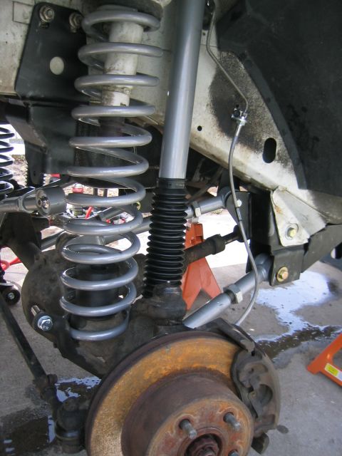 1997 Jeep Cherokee - Close-up of the front suspension of a 1997 Jeep Cherokee, showing lifted springs and shocks.