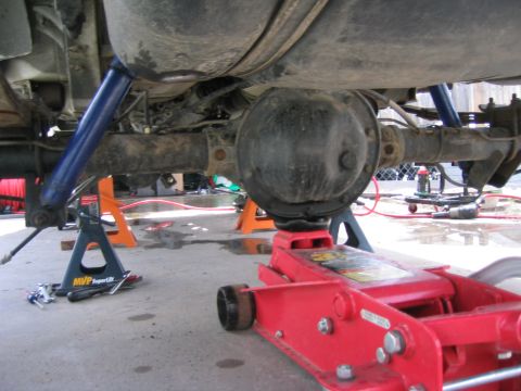 1997 Jeep Cherokee - The rear axle assembly of a vehicle is elevated on jack stands and a floor jack for maintenance or repair.