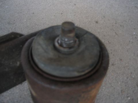 1997 Jeep Cherokee - Close-up of a vehicle's rusty shock absorber top mount, with visible text from Supermotors.net.