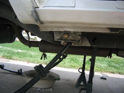 1997 Jeep Cherokee - Close-up view of the undercarriage, focusing on the suspension and exhaust components of a vehicle.