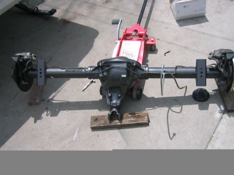 1997 Jeep Cherokee - Rear axle assembly, likely from a Jeep Cherokee, undergoing installation or maintenance.
