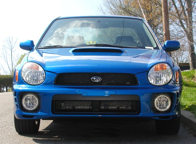 Front view of a blue 2002 Subaru Impreza WRX with a hood scoop and fog lights
